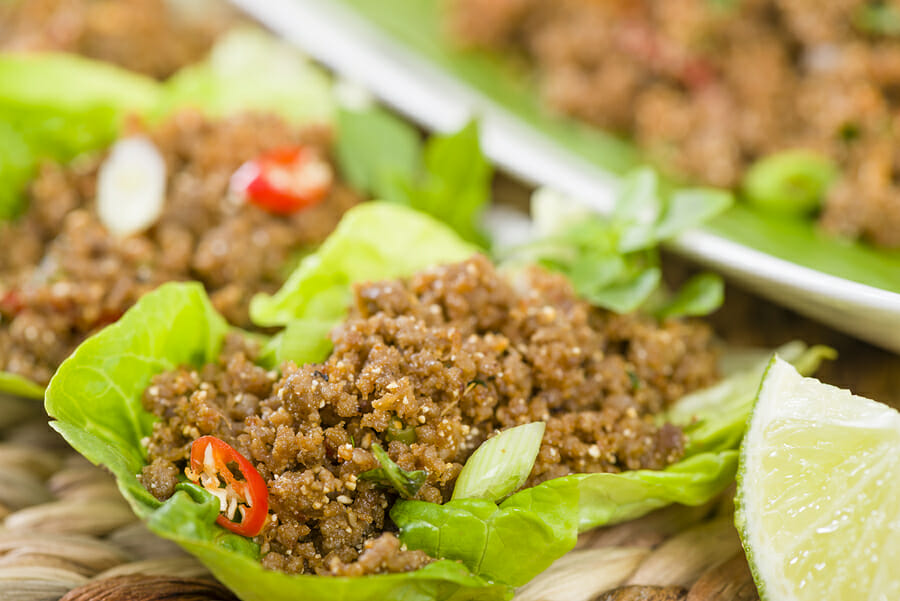 Larb - Lao minced beef salad with fish sauce, lime juice, roasted ground rice and fresh herbs served with lettuce leaves for wraps.